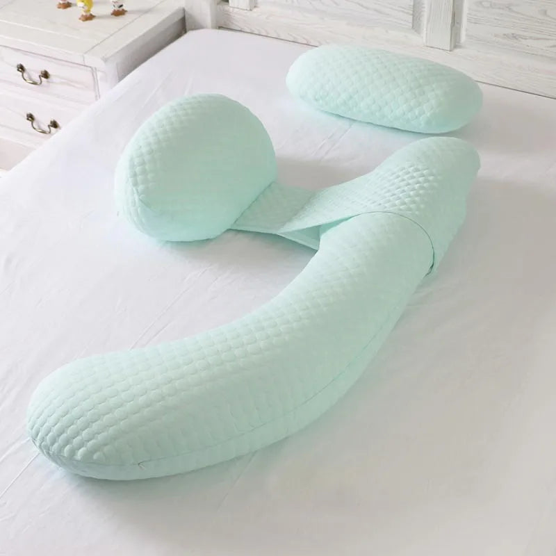 Coussin Allaitement Ergonomique et Apaisant sur un lit avec une table de nuit à gauche